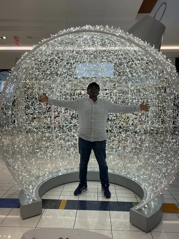 Person standing inside a large illuminated sphere