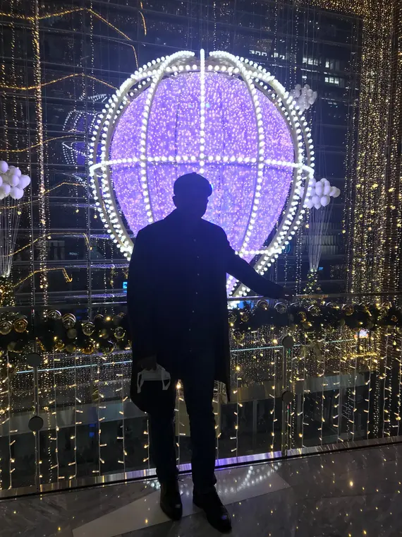 Silhouette standing before a large illuminated globe